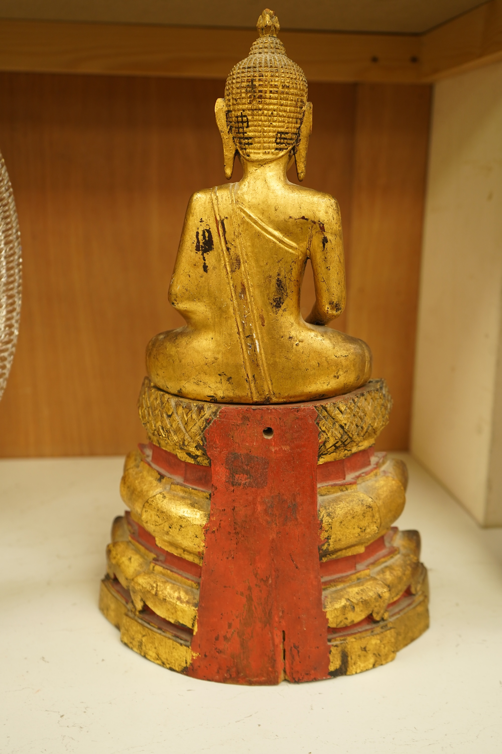 A 19th century Burmese giltwood figure of seated Buddha, 40cm high